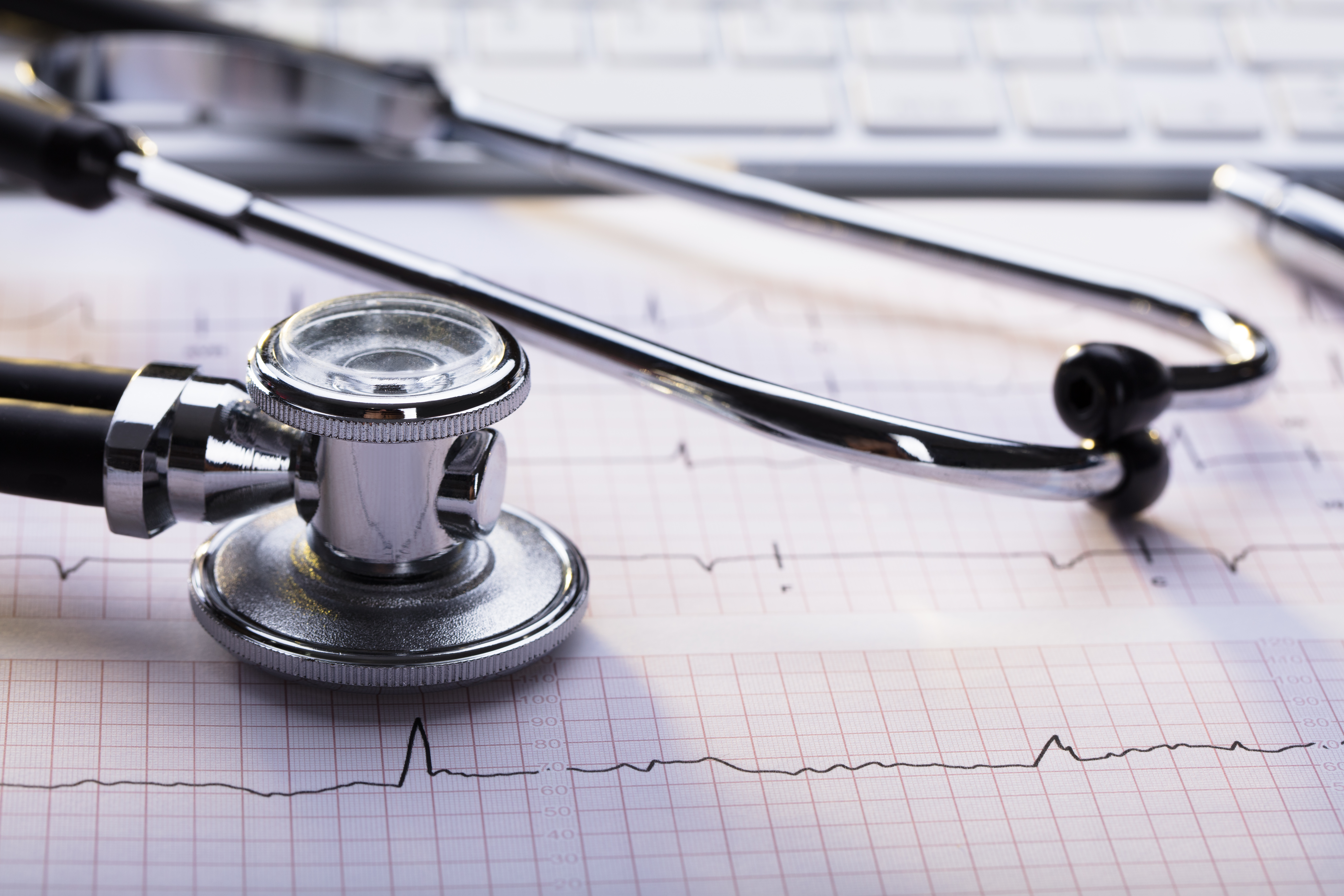 tests required for a cardiology consultation - a stethoscope and an EKG chart